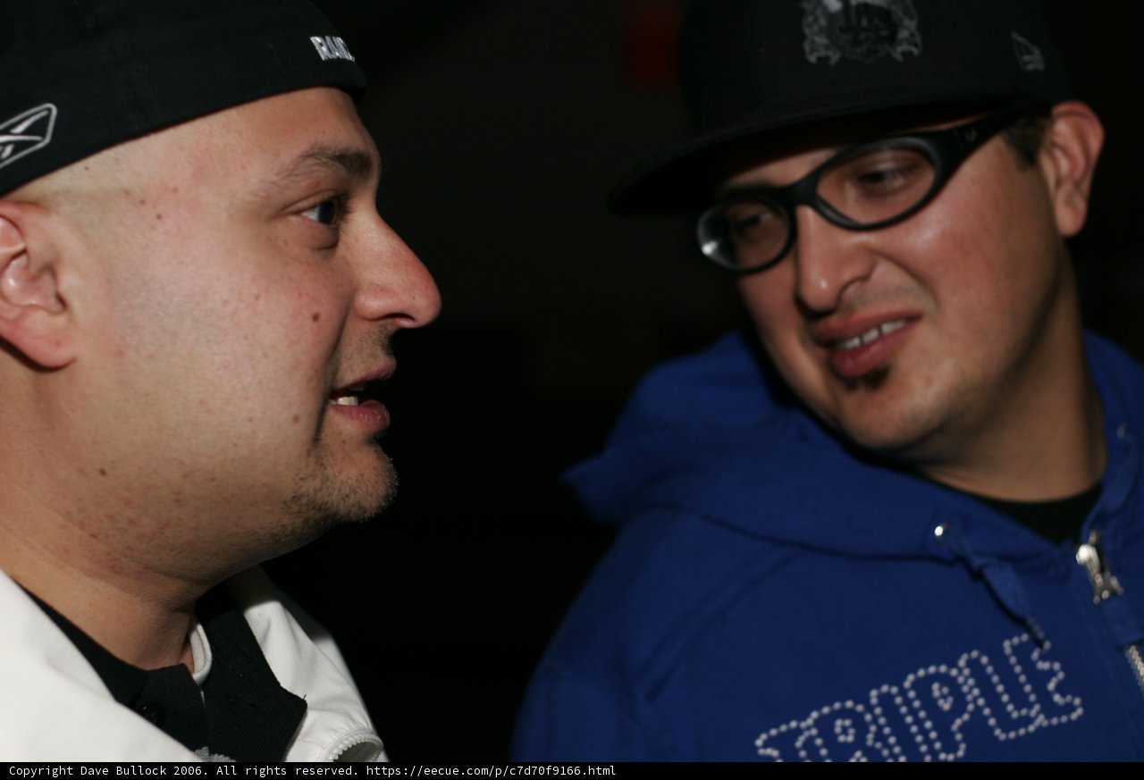 Two Men Chatting in Their Caps