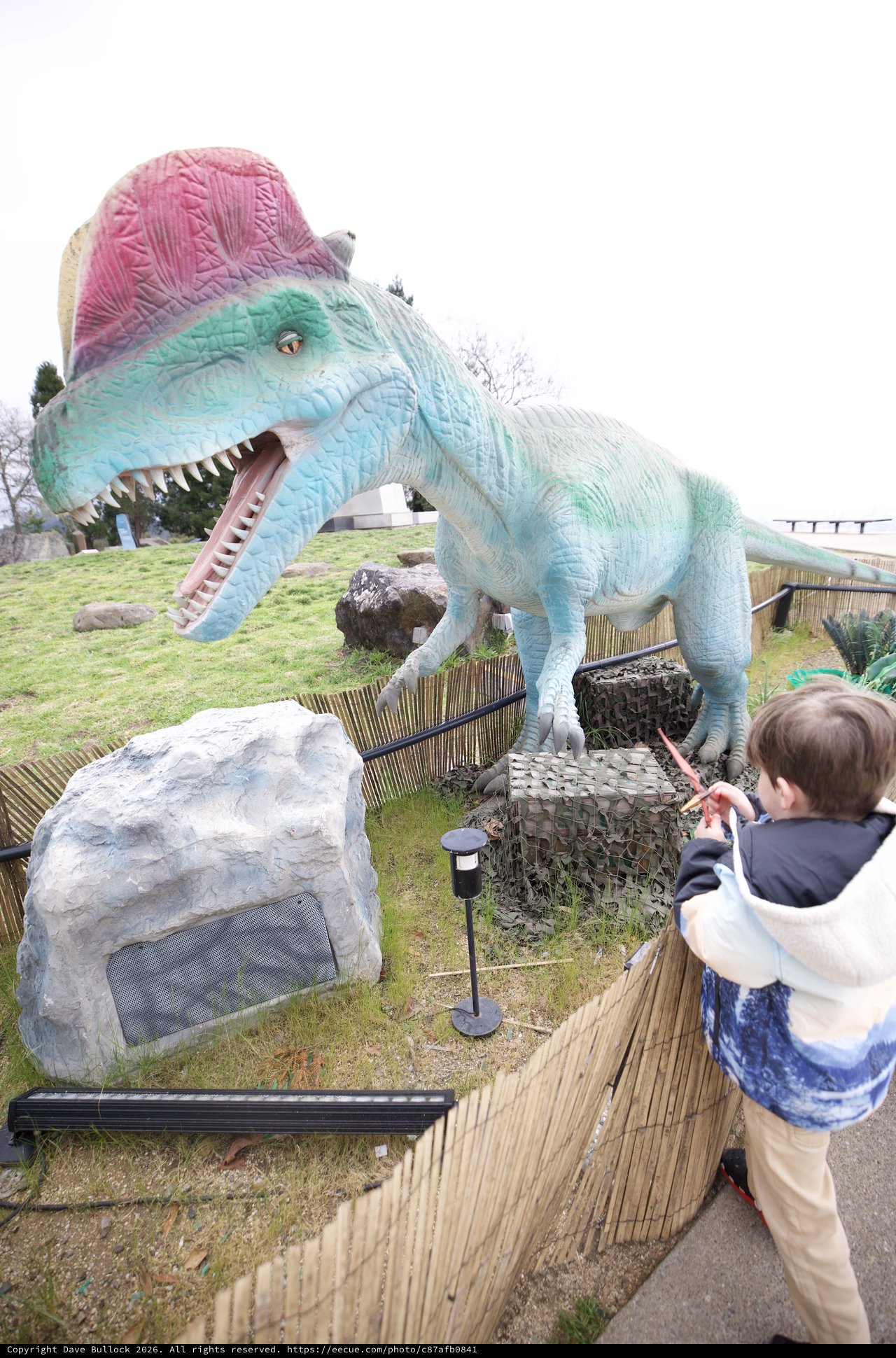 Child Confronts Colorful Spinosaurus at Dinosaur Park