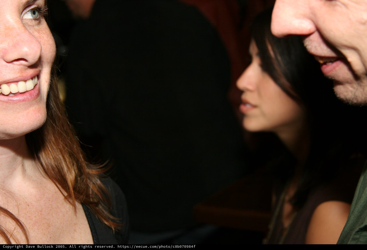 Candid Social Gathering with Smiling Woman in Foreground