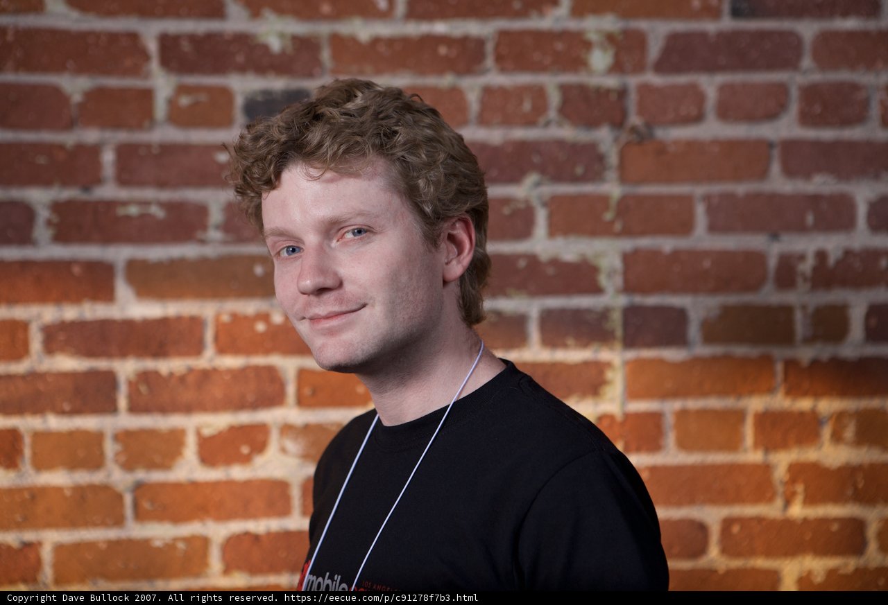 Curly Haired Teen Stands Proudly before Brick Wall