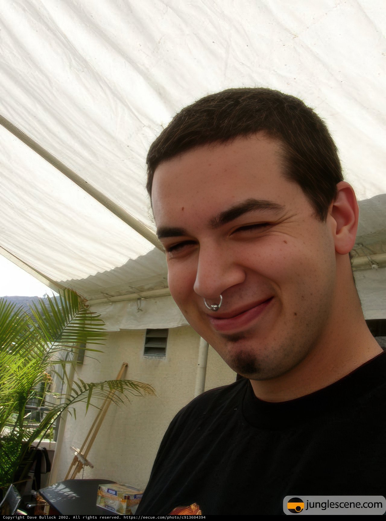 Smiling Man with Nose Ring in Lush Greenery