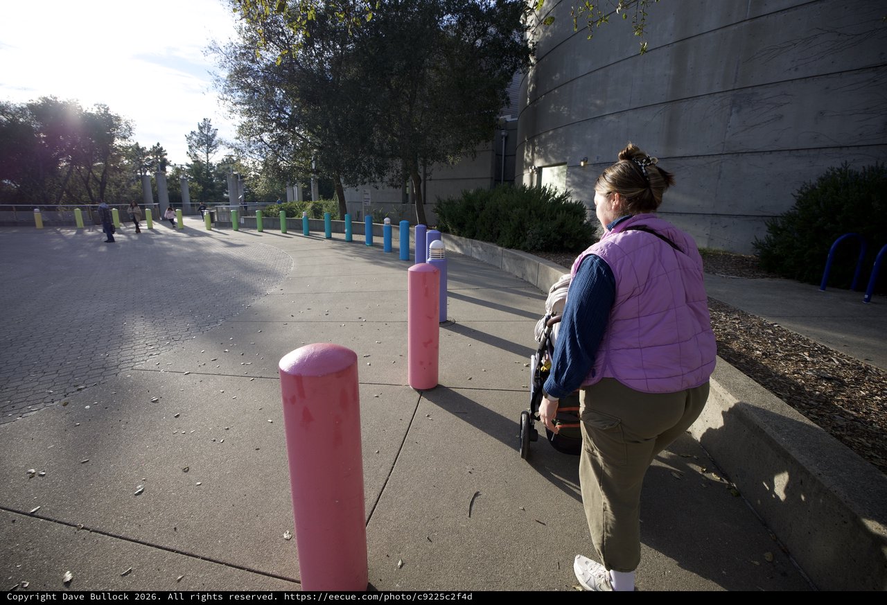 Parent and Child Exploring Colorful Bollard Installation