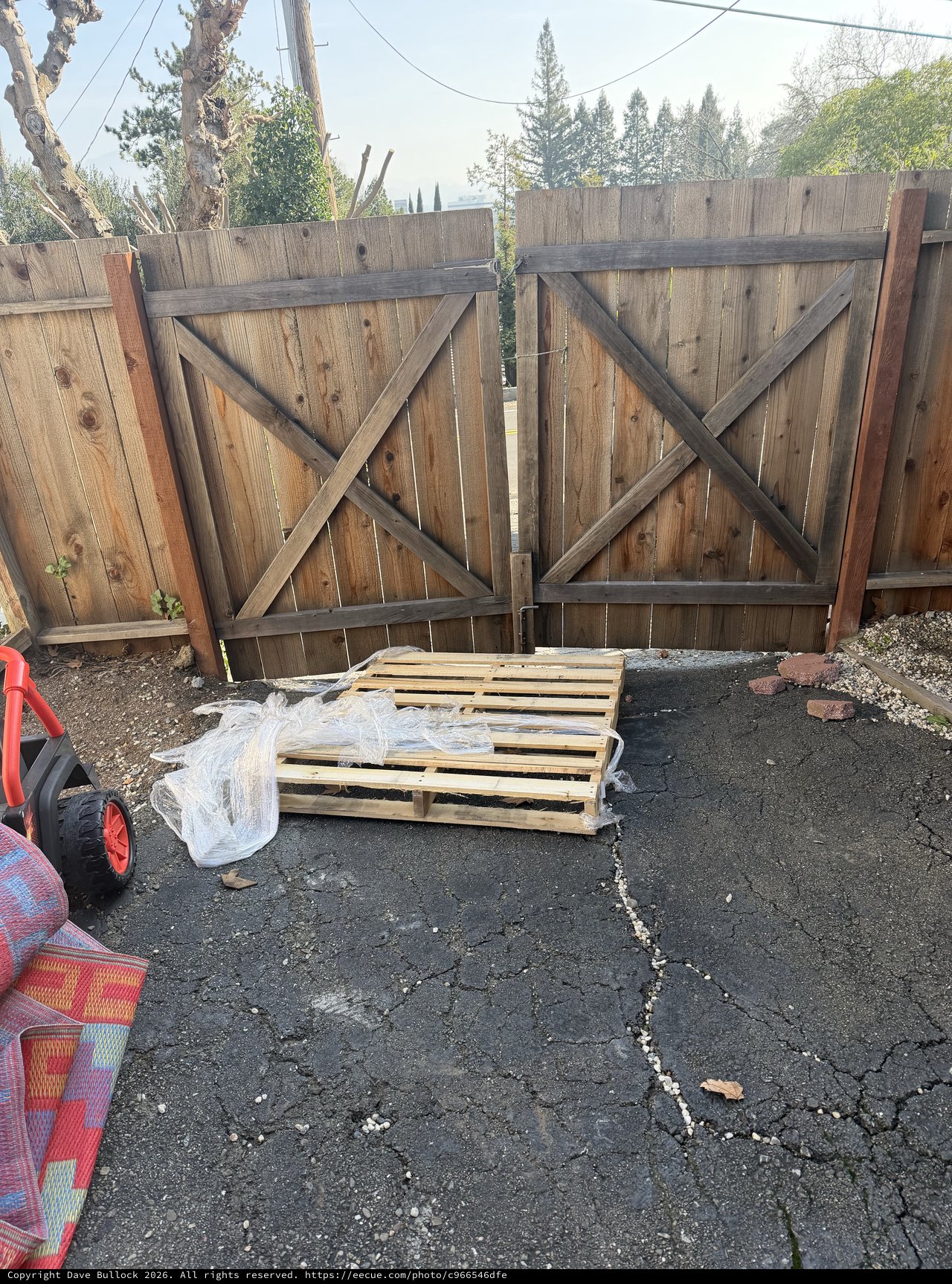 Weathered Wooden Gate with Wooden Pallet in Driveway