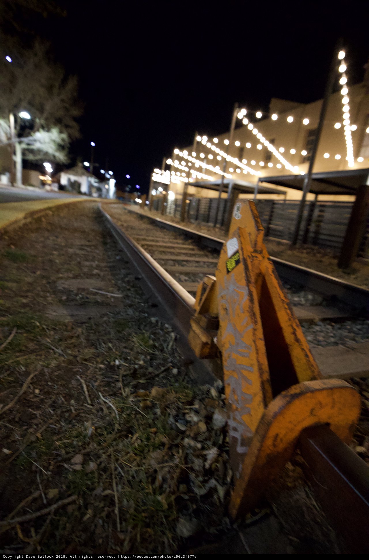 Railroad Tracks at Night with String Lights