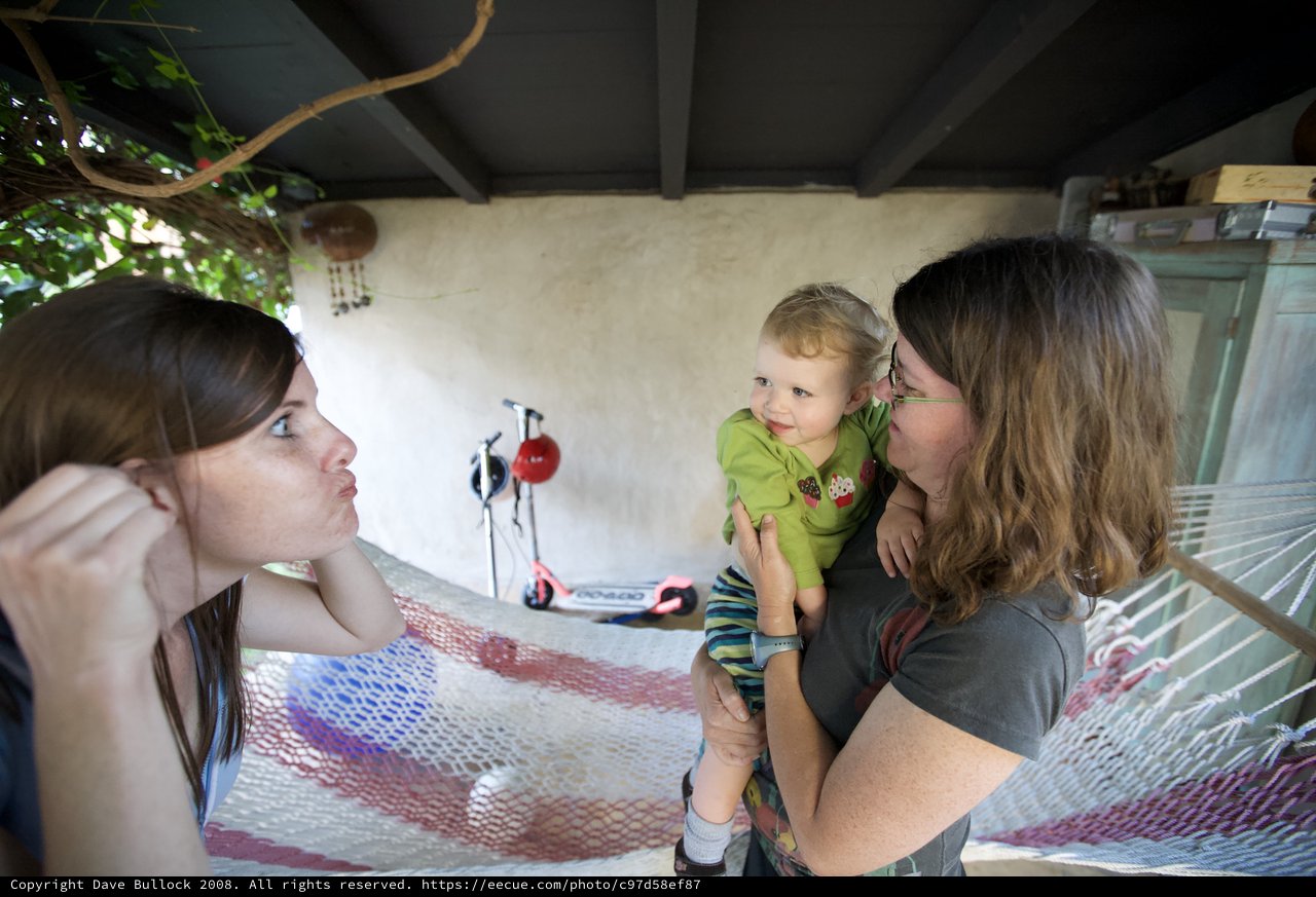 Two Women Delight in Baby's Cheek Kisses