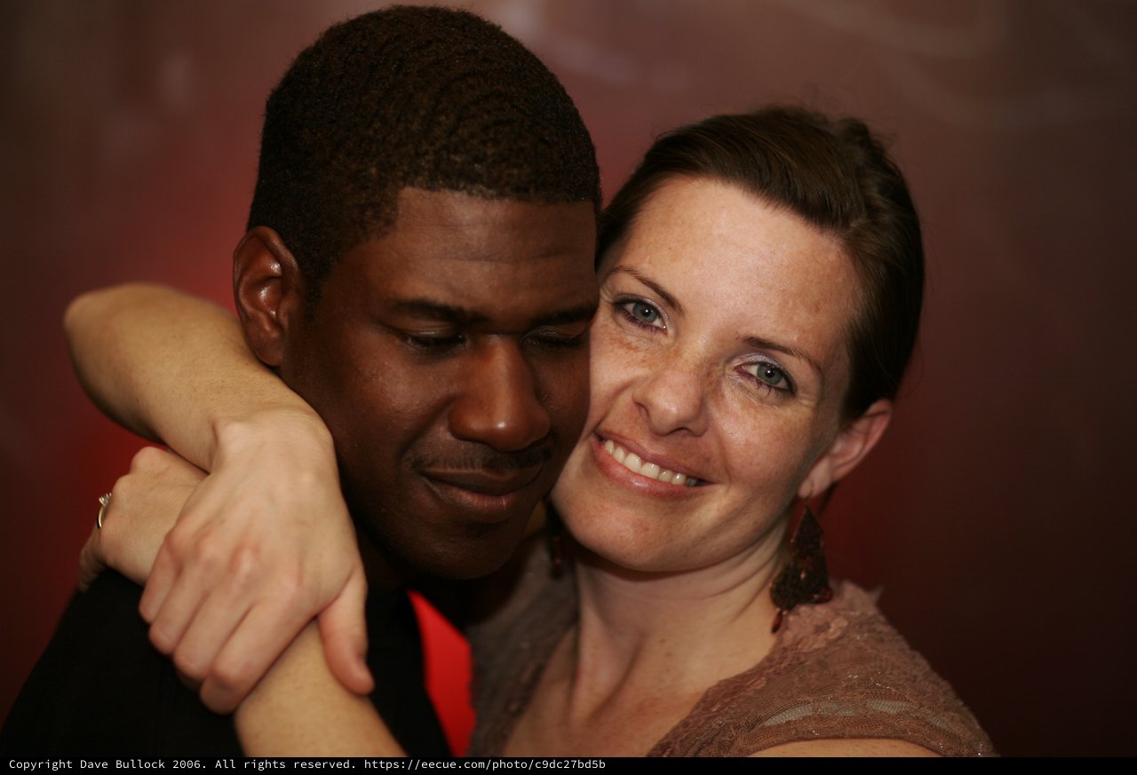 Intimate Embrace at a Dimly Lit Evening Event