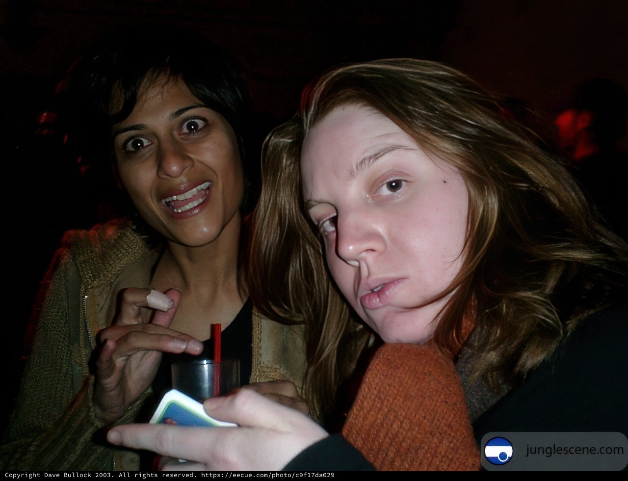 Two women posing with their mobile phones