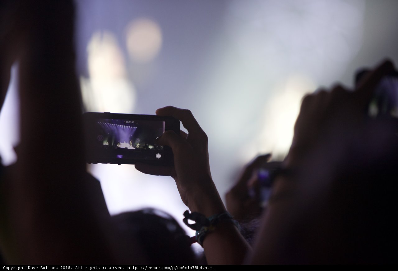 Snapping Memories Caption: A woman captures the moment on her phone at Coachella 2016.