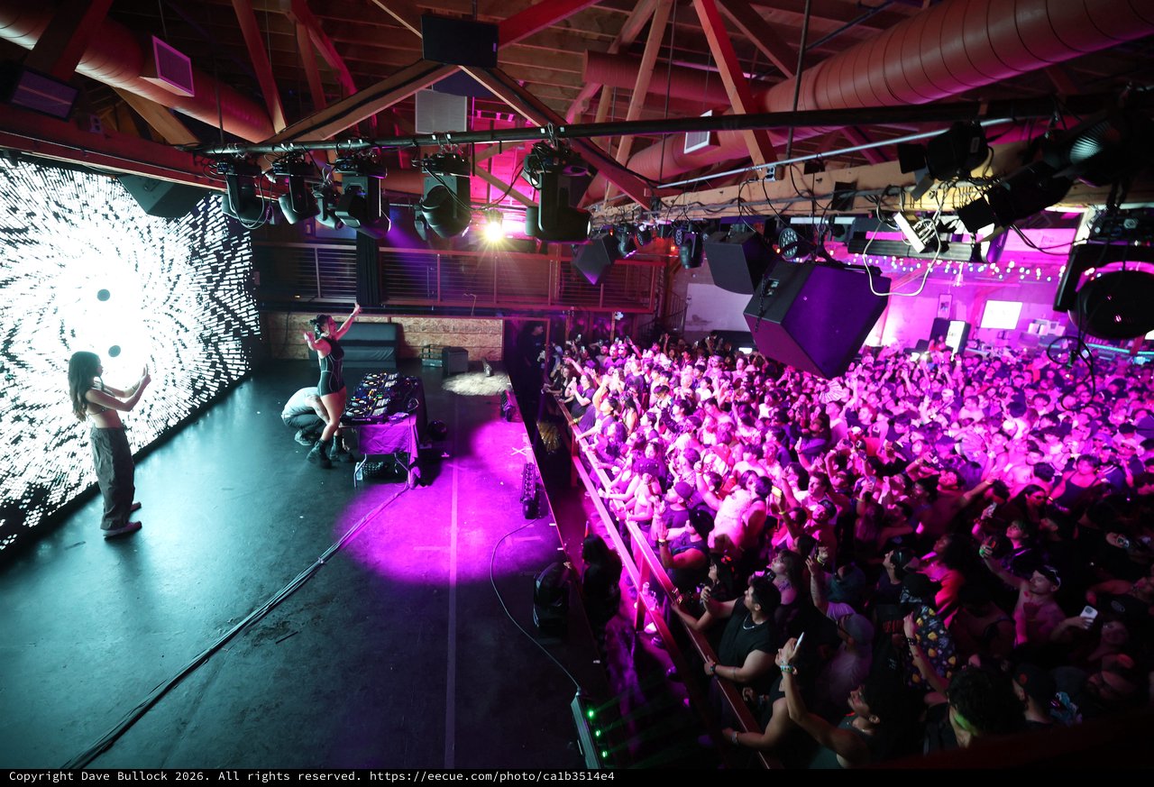 Packed Dance Crowd Pulses Under Violet Stage Lights