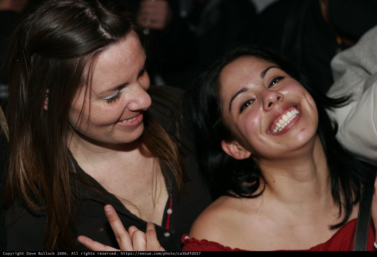 Two Friends Laughing Together at a Nighttime Event