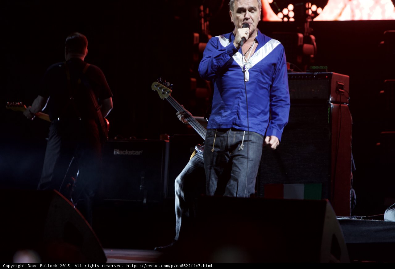 Morrissey Full Body Singing Blue Shirt Bassist Behind Blackstar Amps Italian Flag Red Lighting