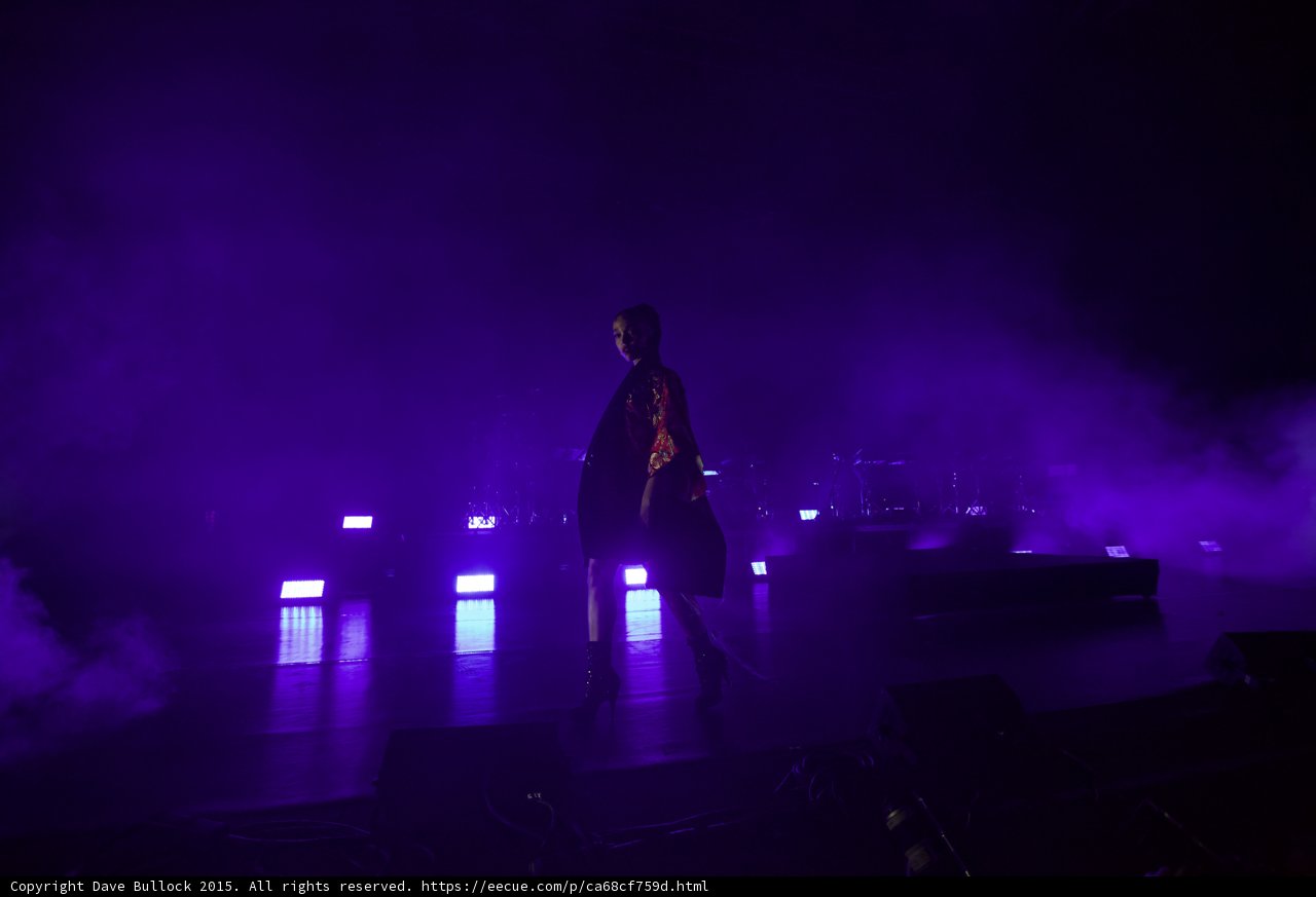 FKA twigs Wide Stage Purple Lighting Red Brocade Kimono Looking Toward Camera LED Lights Band Haze
