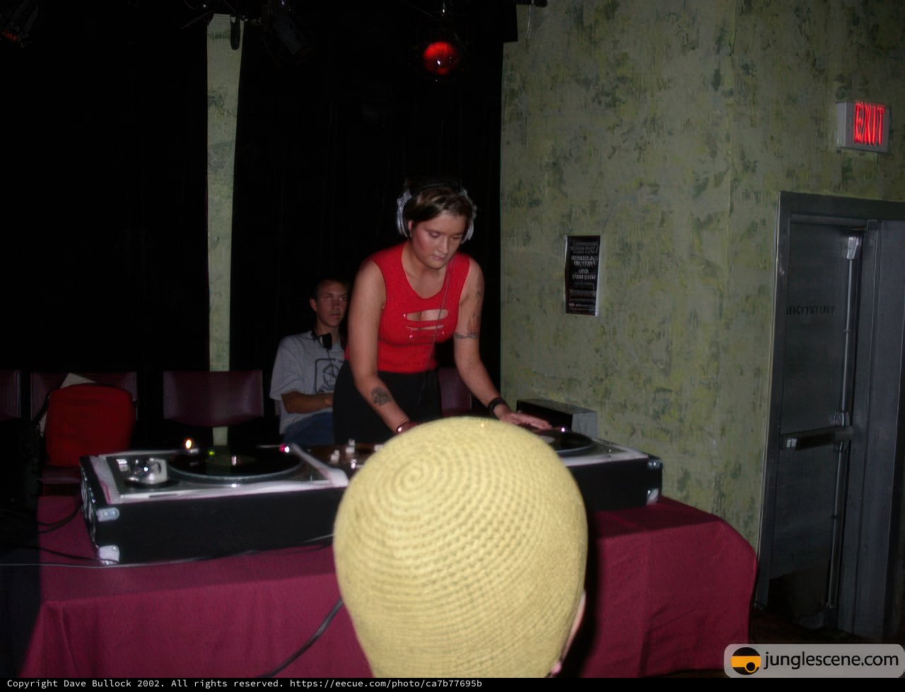 Red Shirt DJ Mixing Music on Turntable