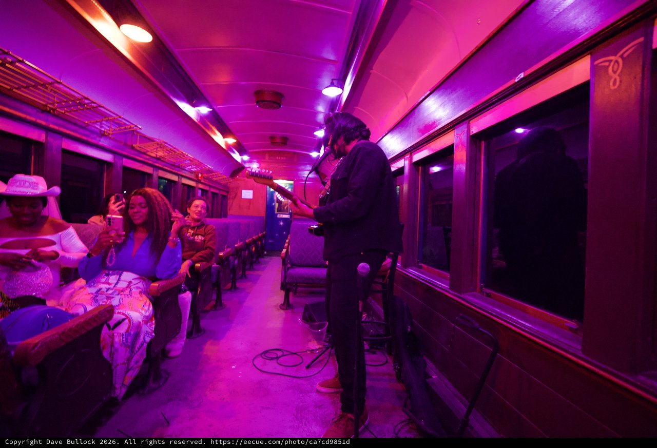 Live Music Performance in Purple-Lit Vintage Train Car