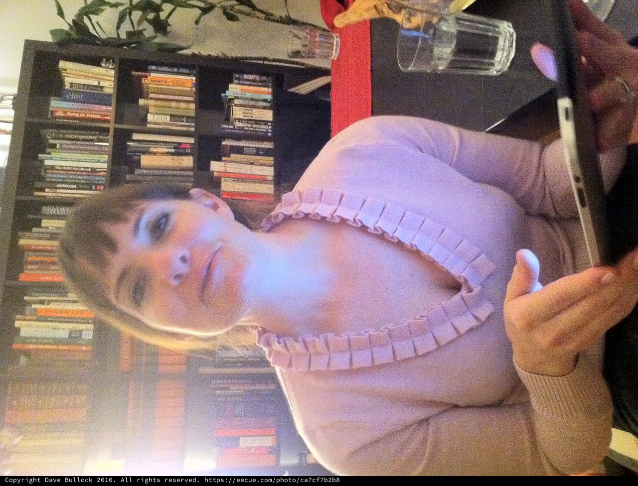 Woman with Tablet in Cozy Home Library Setting