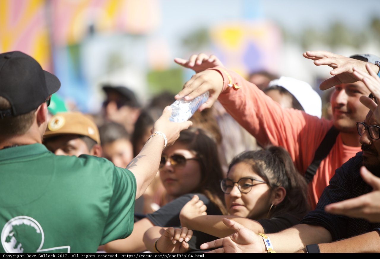 Man giving water to thirsty Coachella crowd