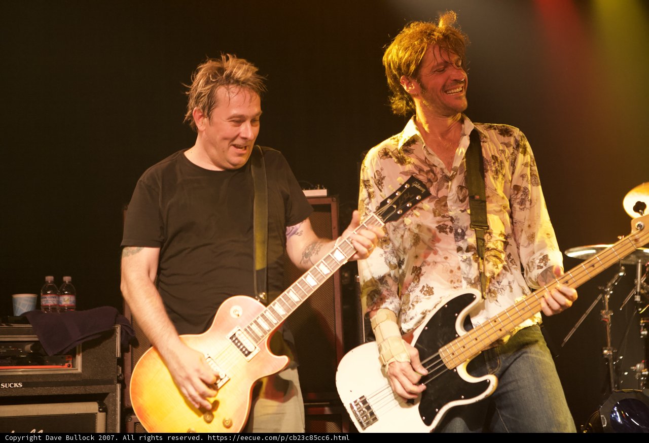 Two Men Jamming on Stage with Guitars