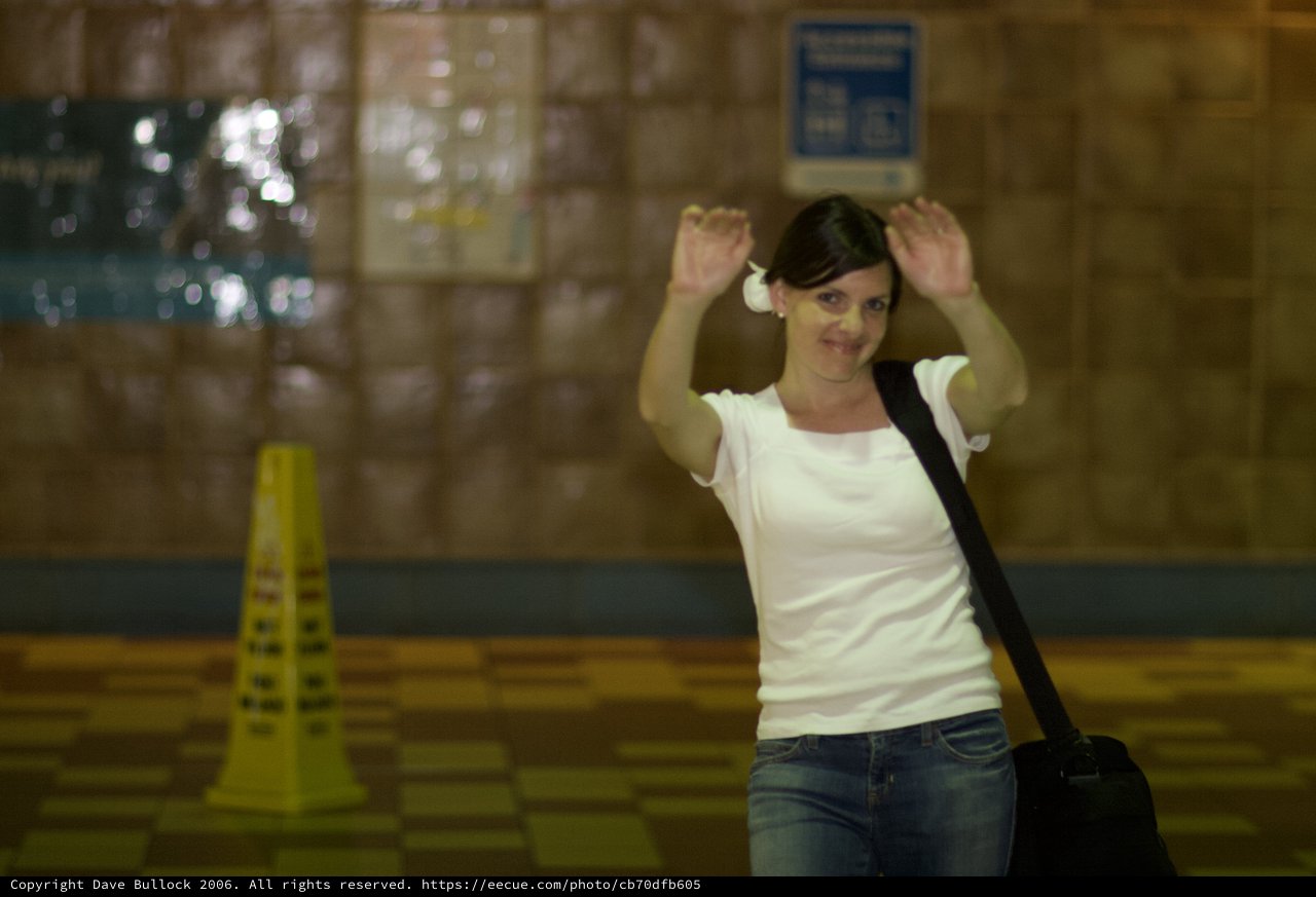 Playful Woman Raising Hands in Transit Station
