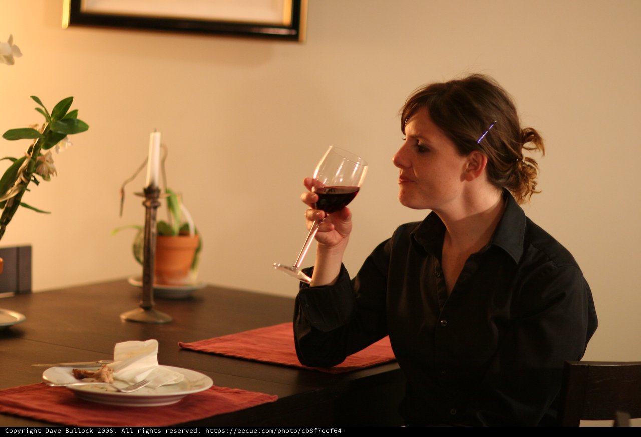 Thoughtful Woman Savoring Red Wine at Dinner