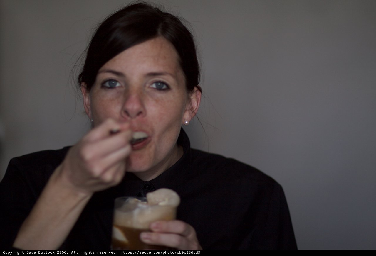 Woman Enjoying a Dessert Drink at Evening Gathering