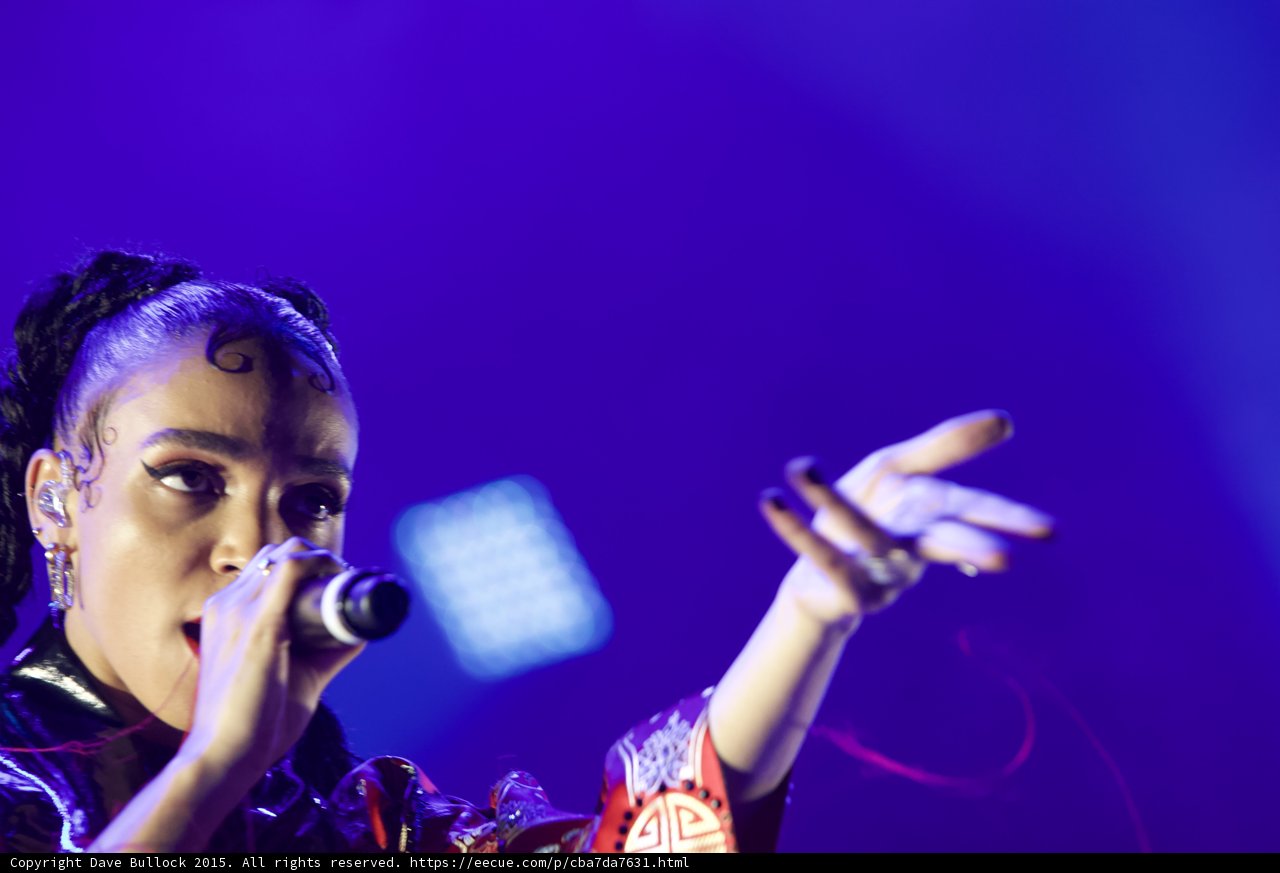 FKA twigs Incredible Close-Up Portrait Arm Extended Expressive Hand Rings Baby Hairs Swirls Cat-Eye Makeup Hoop Earrings Red Lipstick Braided Ponytails Kimono Purple Blue Lighting LED Panel