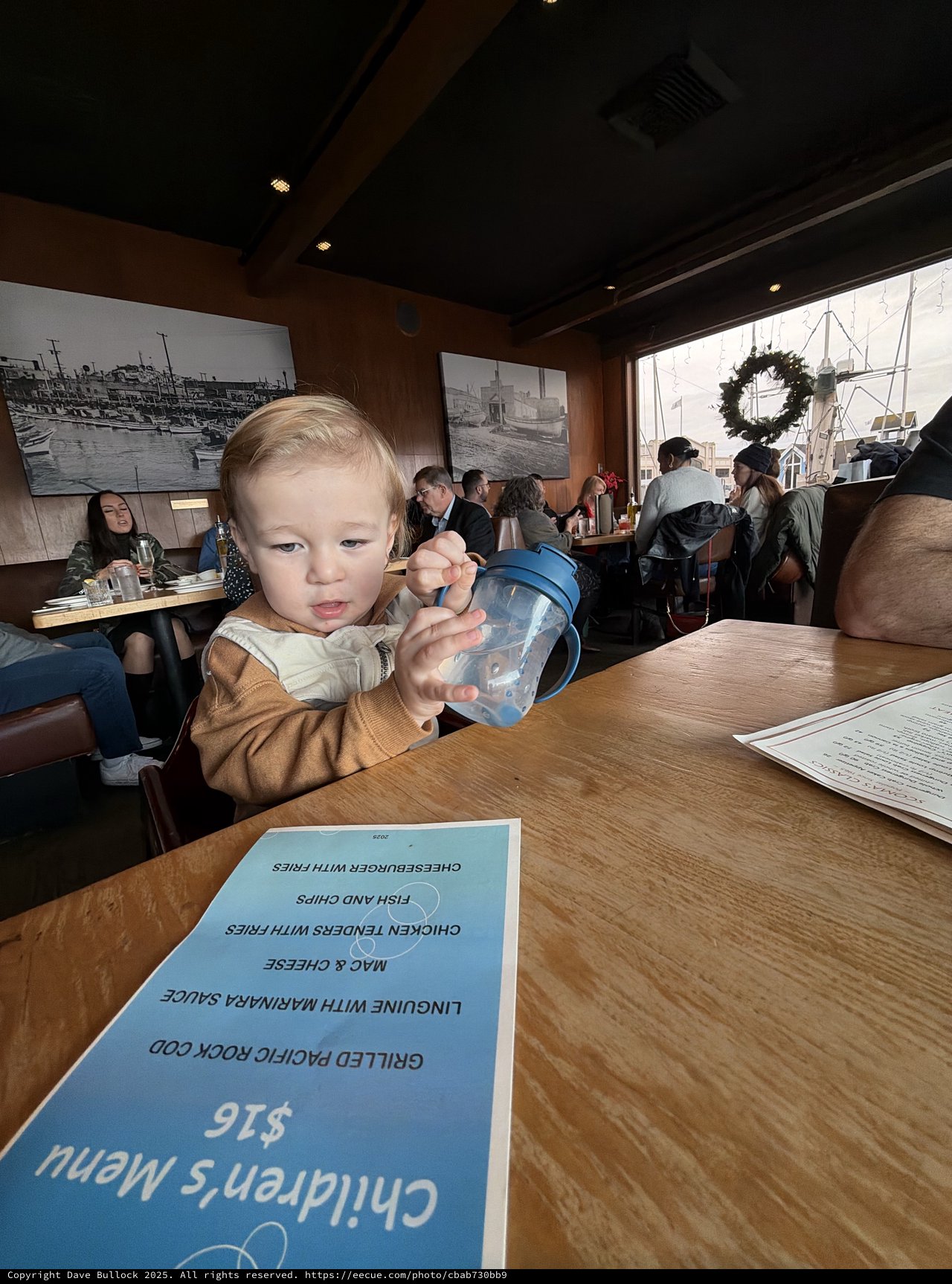 Young Child with Sippy Cup at Restaurant Table