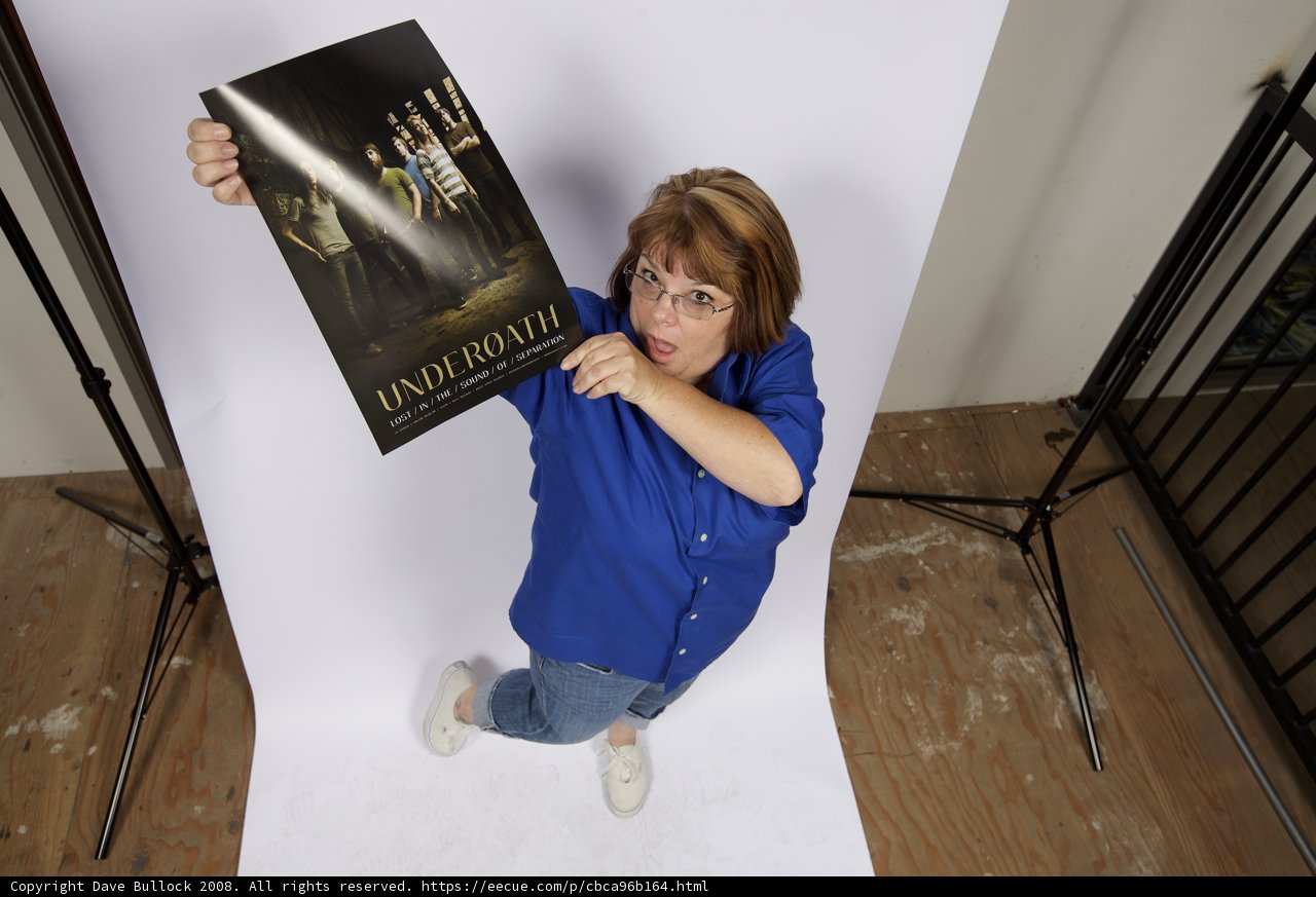 Woman Holds Poster Promoting Wood Flooring