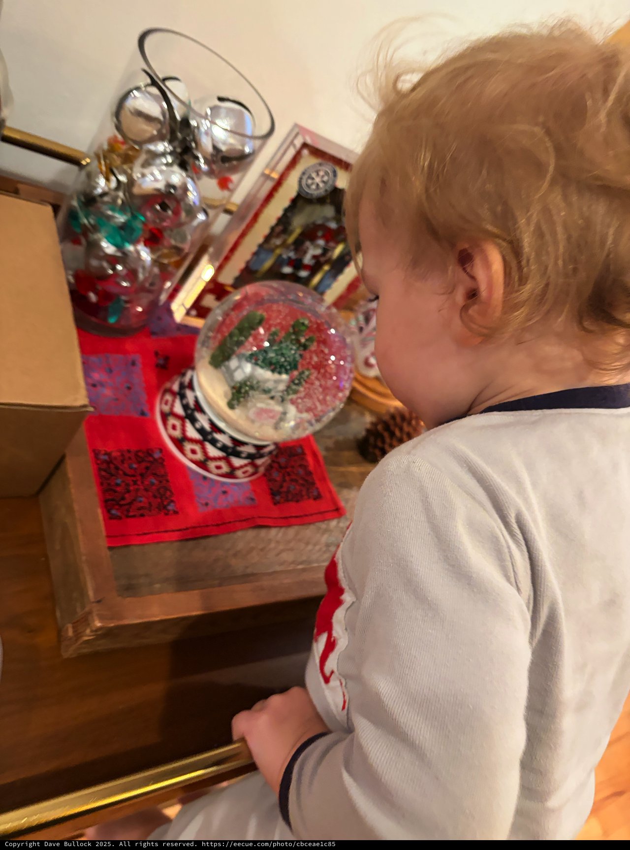 Child Admiring Snow Globe Collection at Bedside
