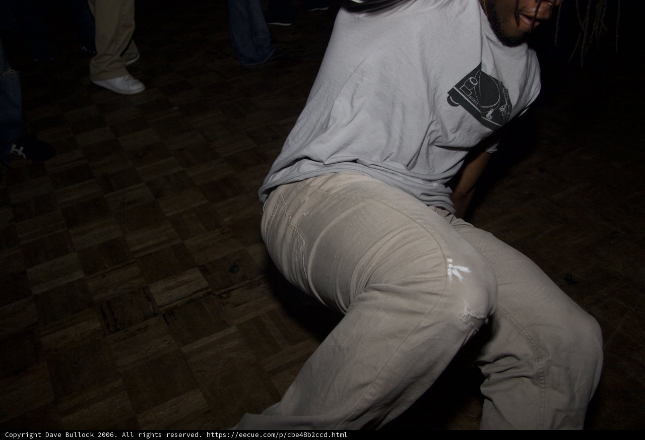 Man Dancing on Hardwood Floor in White T-Shirt