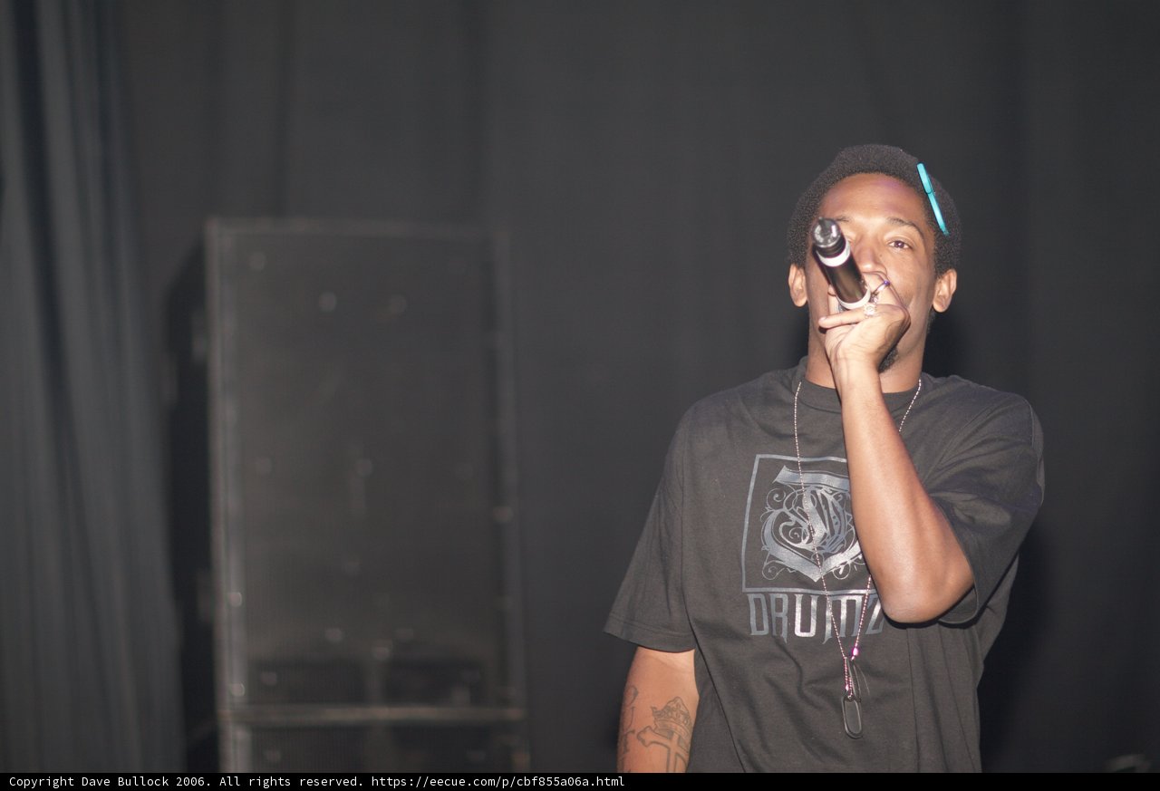 Man with a Microphone Takes the Stage in Black T-Shirt