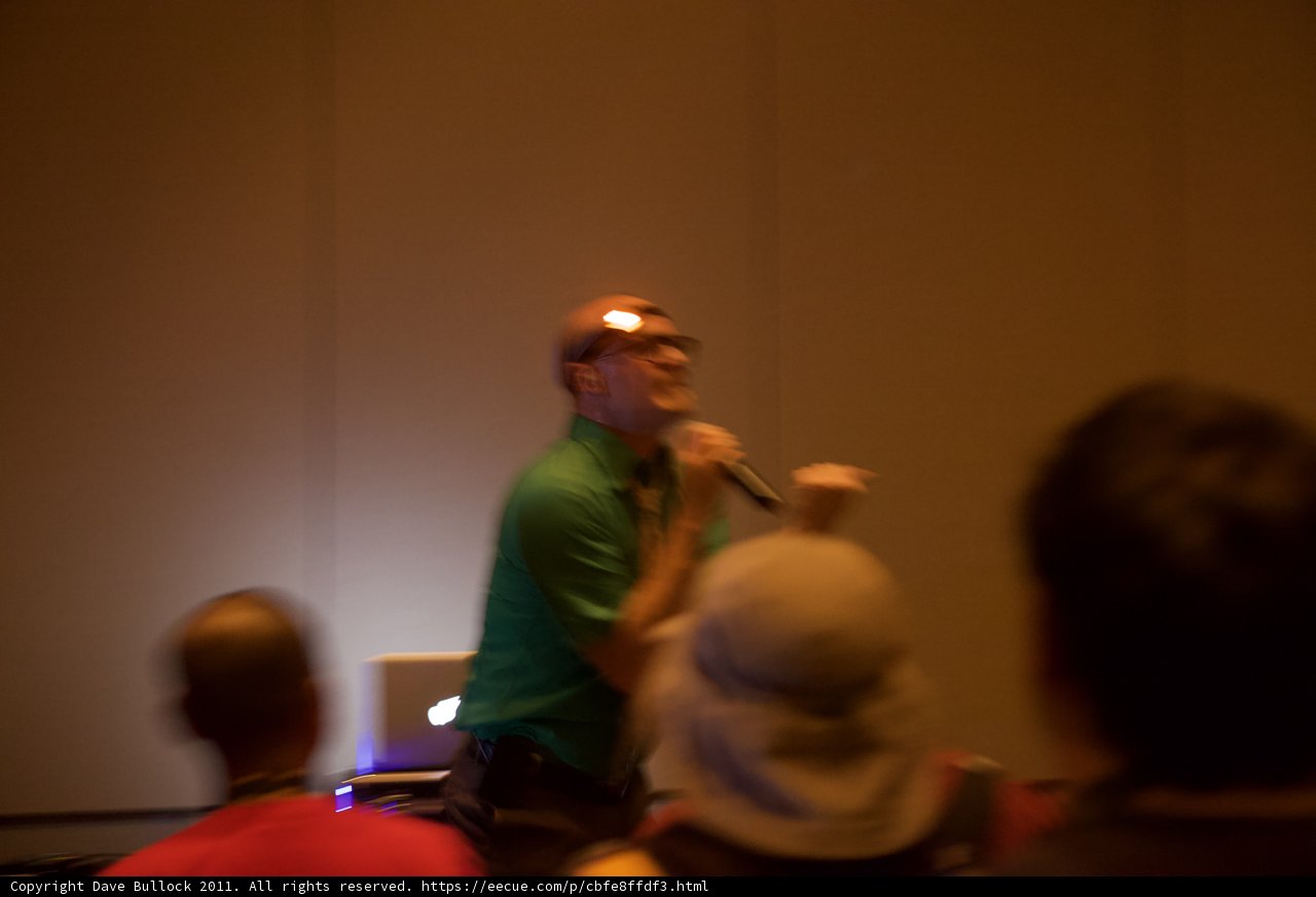 Green-Shirted Man Holds Microphone at Seminar