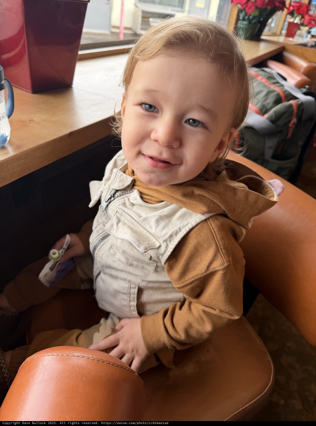 Joyful Toddler Smiling at Café Table