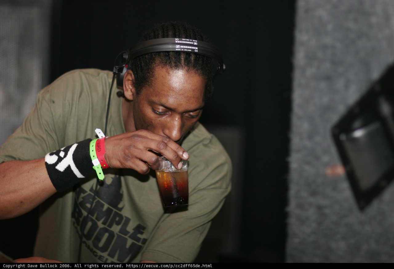 Dreadlocked man sipping from a glass