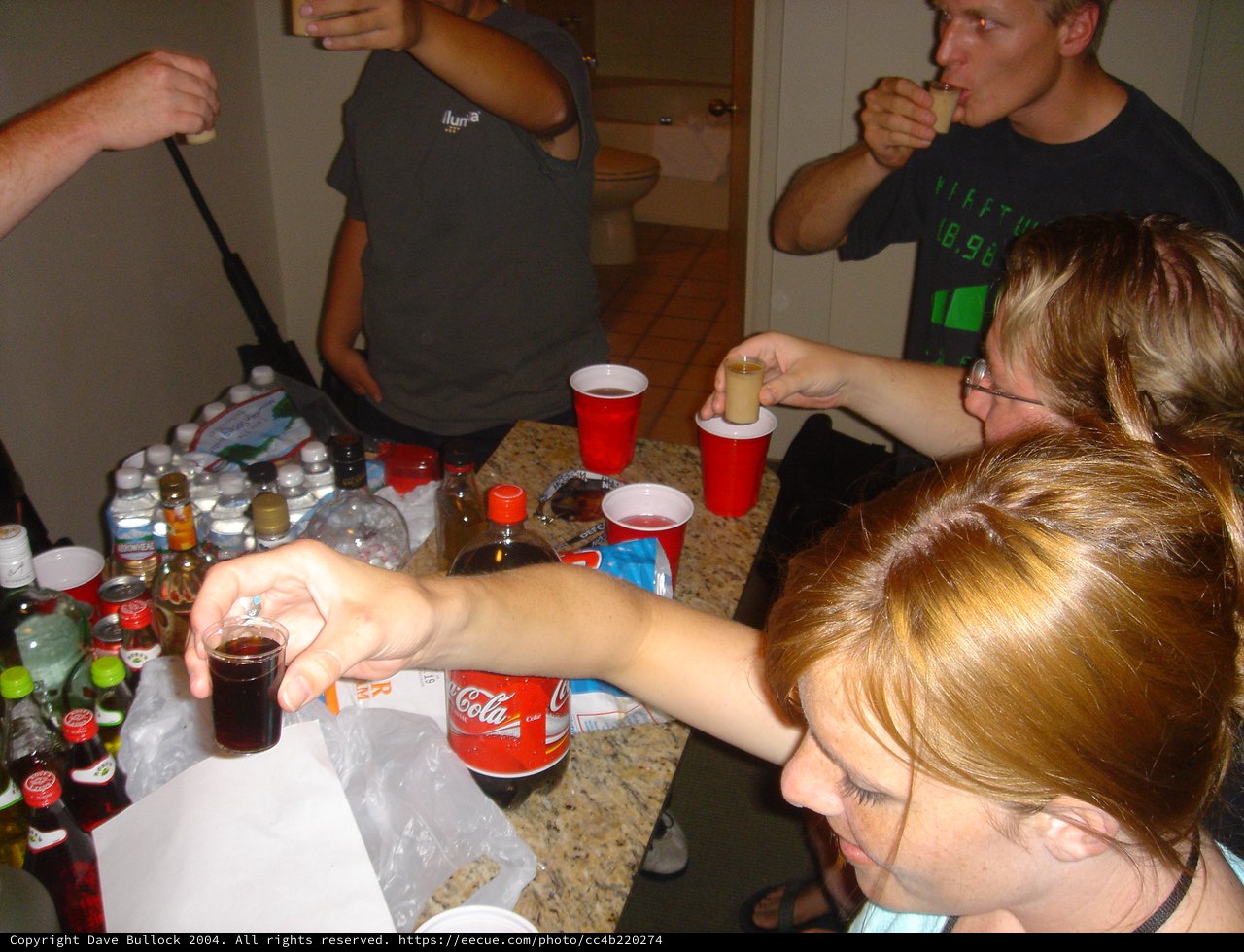 Late Night Party Shots Around a Crowded Bar Table