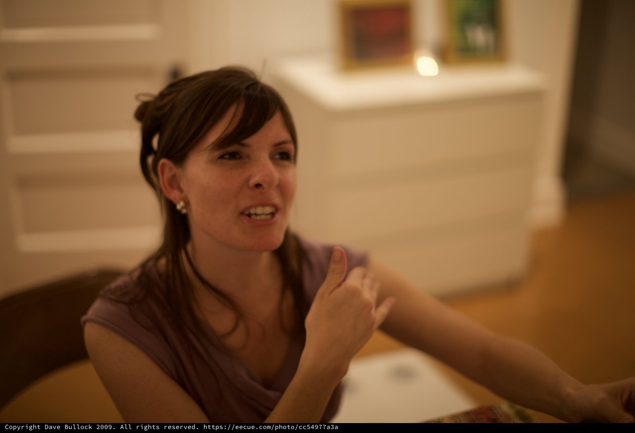 Penelope in Animated Conversation at Indoor Gathering
