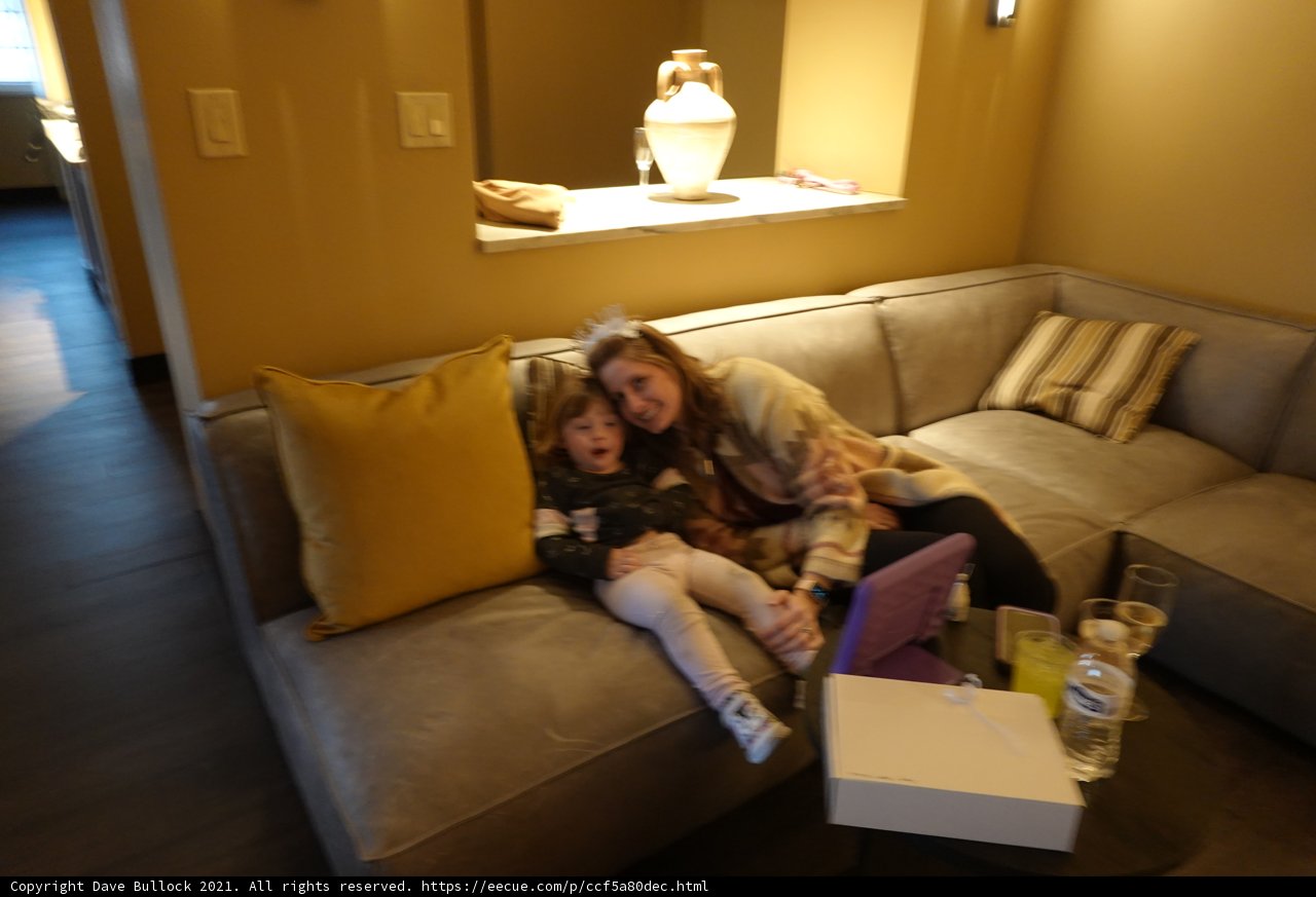 Cozy Afternoon in Santa Fe Caption: A mother and her daughter enjoying a relaxing moment on a comfortable couch in their hotel room in Santa Fe, surrounded by beautiful architecture and home decor.