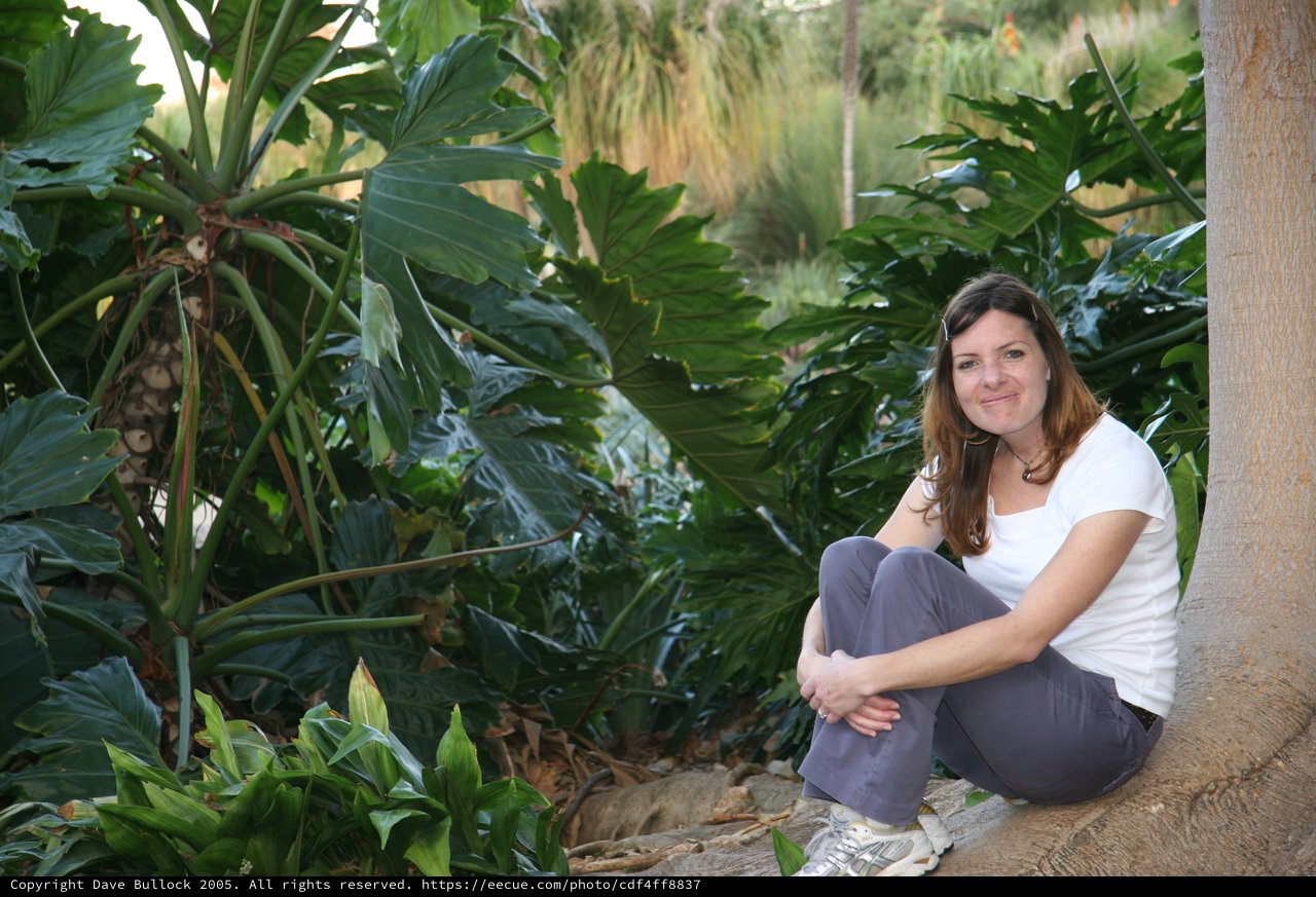 Woman Relaxing Among Lush Tropical Garden Foliage