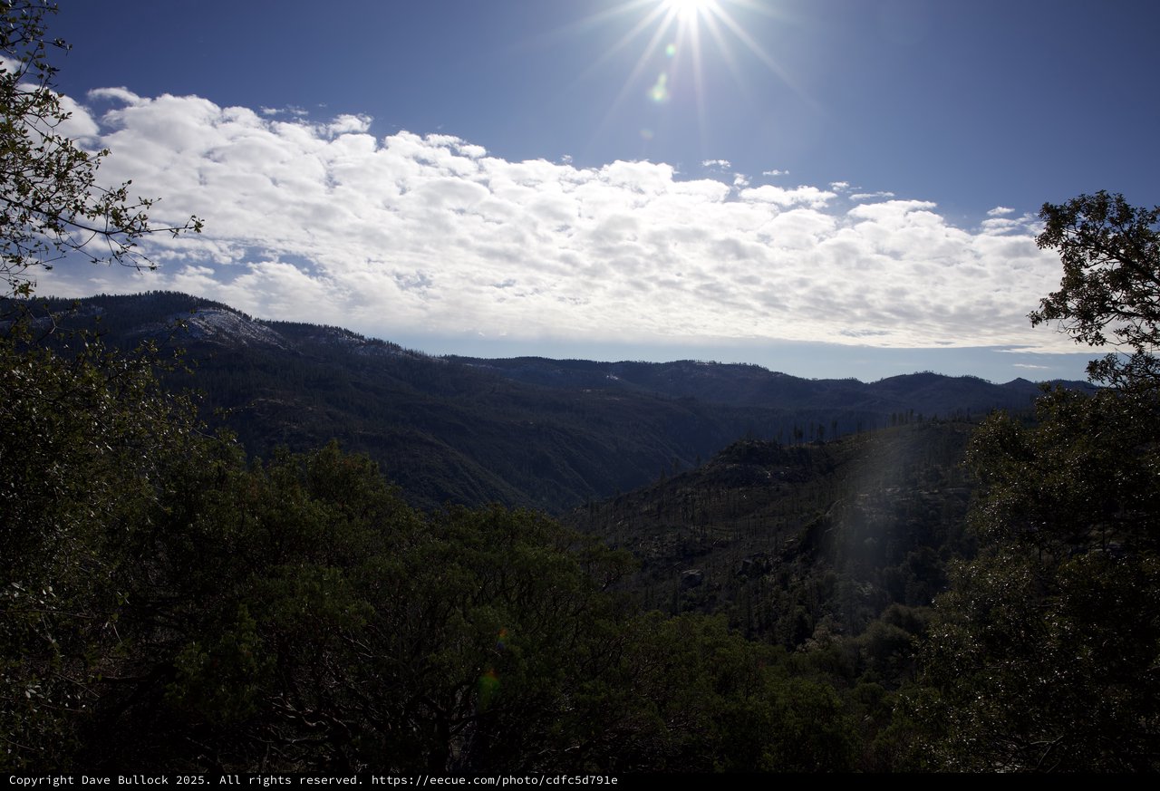 Sunburst Over Forested Mountain Valley in Winter