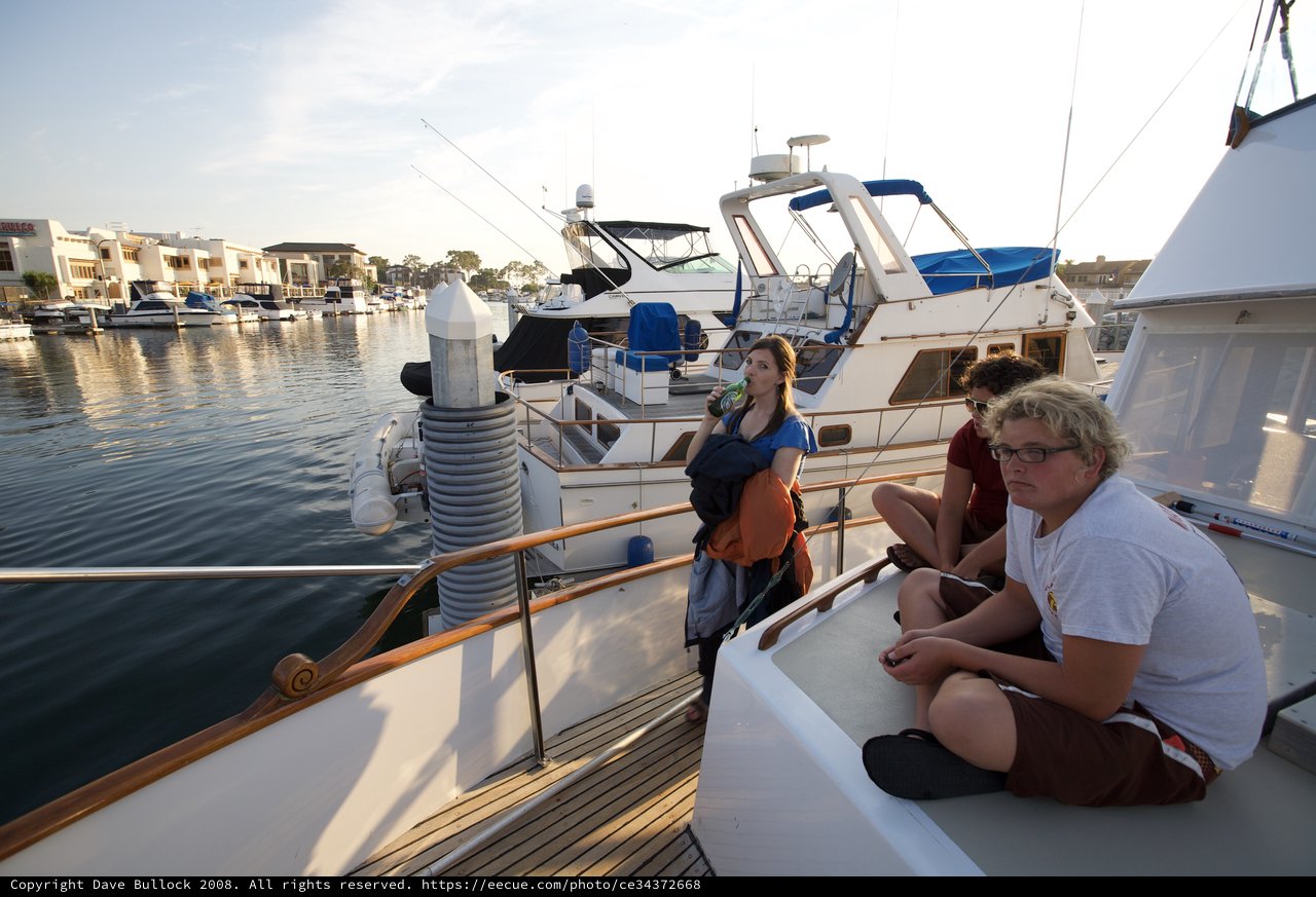 Friends Relaxing on Yacht at Golden Hour Marina