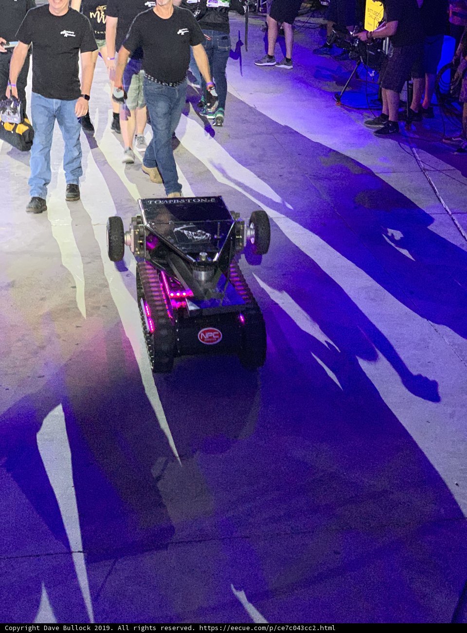 Men Walk with Robot on Las Vegas Speedway