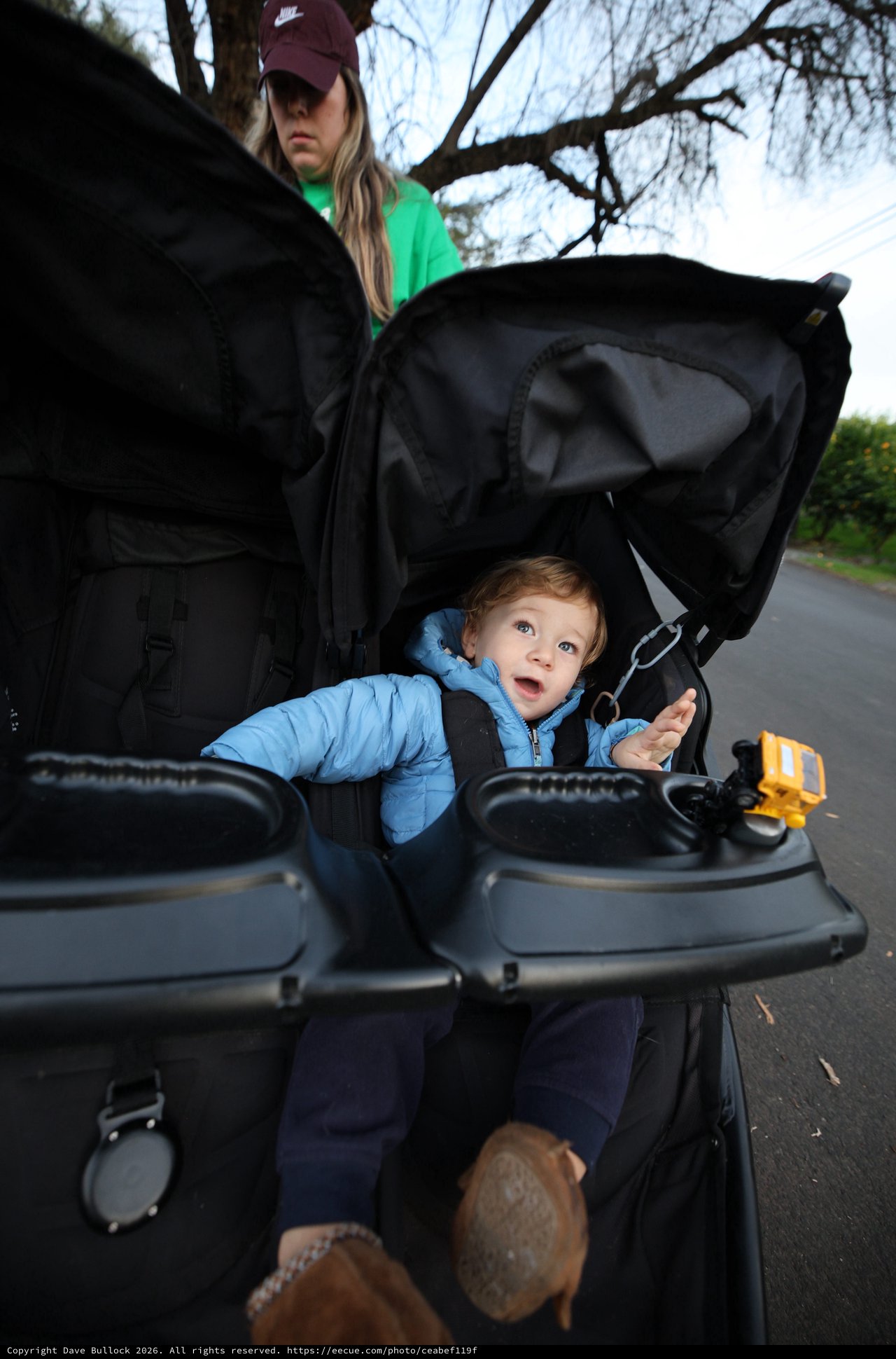 Curious Toddler's Wide-Eyed Wonder in Black Stroller