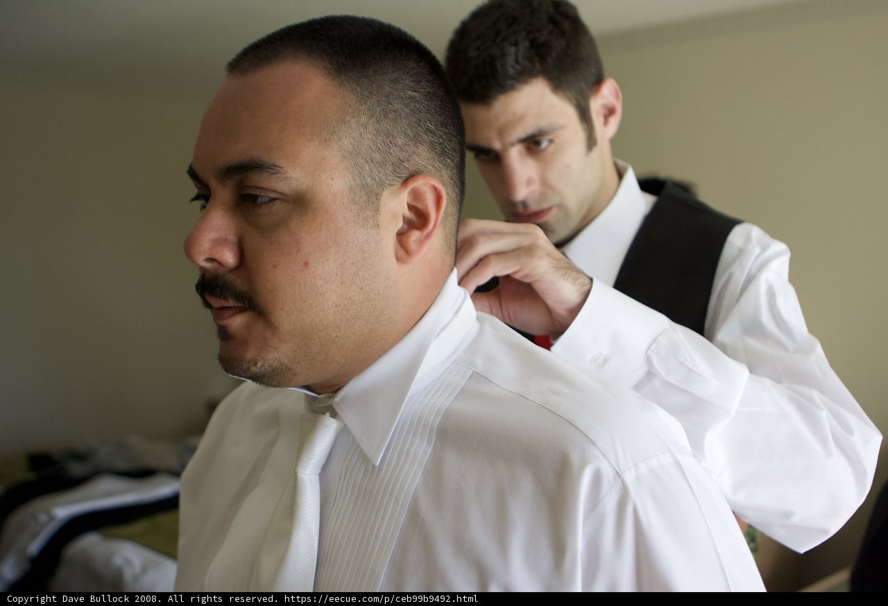 A Sharp Look Caption: Mark B adjusts his tie before heading out, looking sharp in his dress shirt and formal wear.