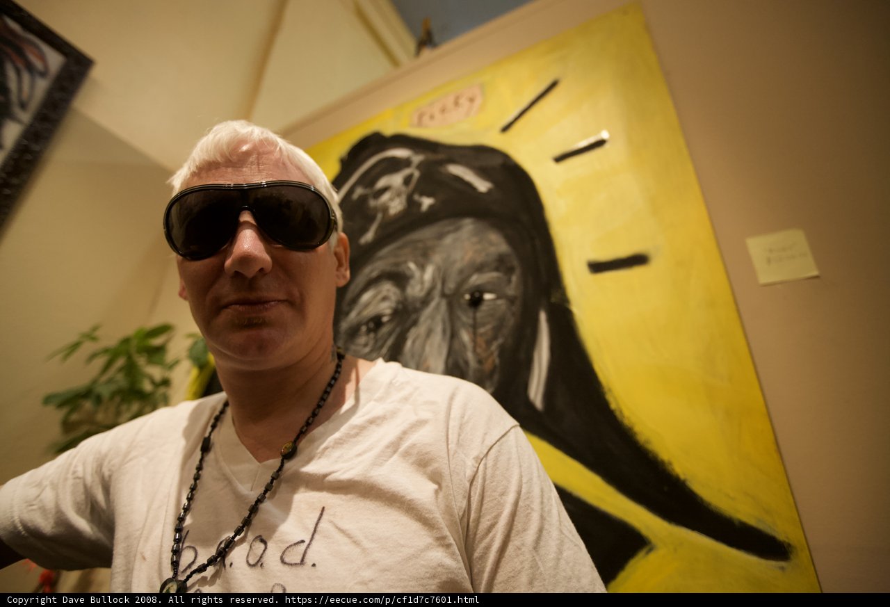 Man Gazing at Artwork in Stylish Sunglasses and White T-Shirt