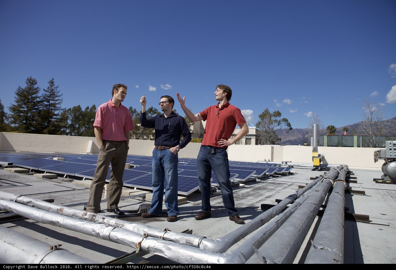 Three Men Install Solar Panels on a Rooftop