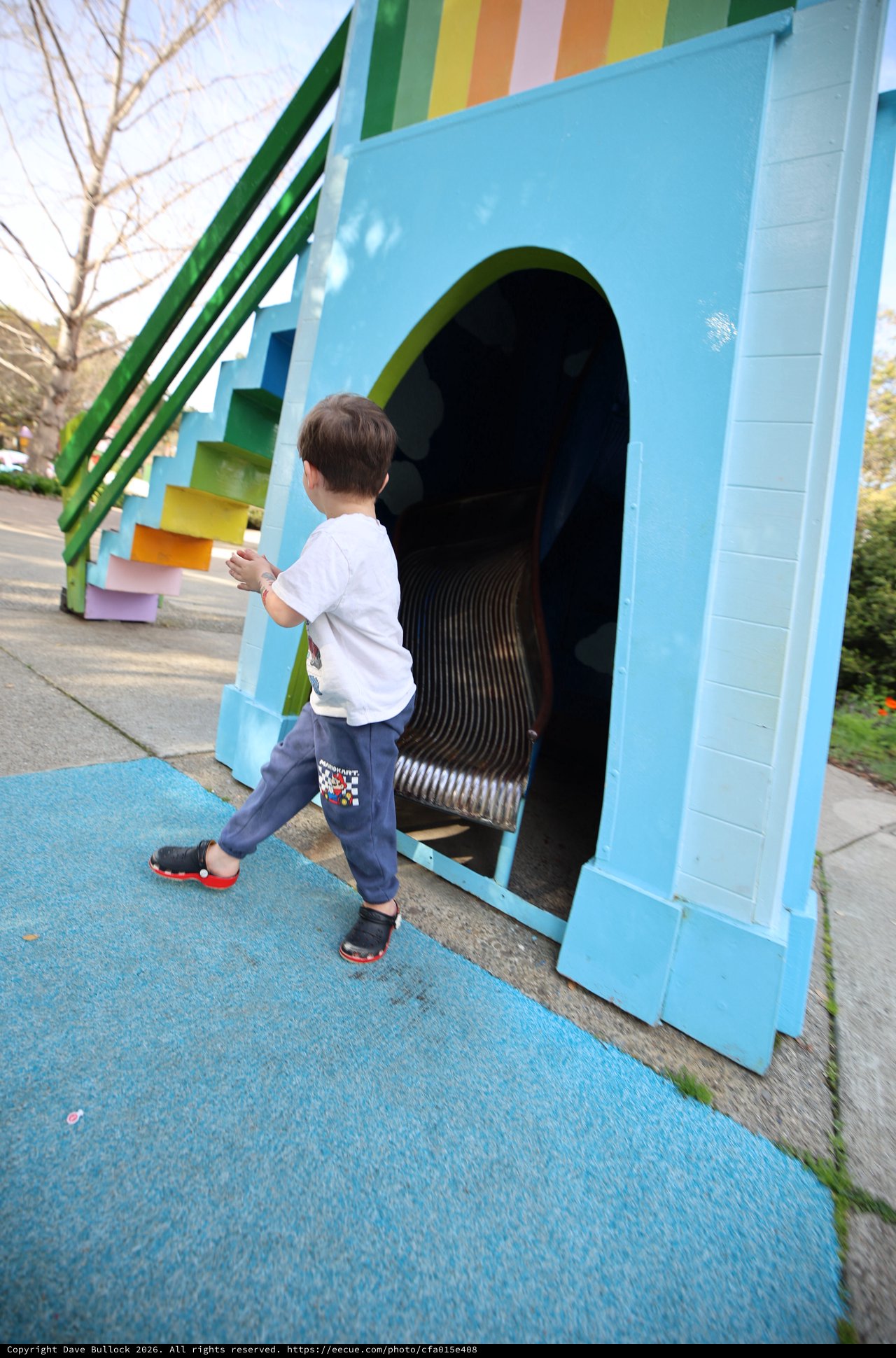 Child Exploring Colorful Rainbow Tunnel Slide at Playground