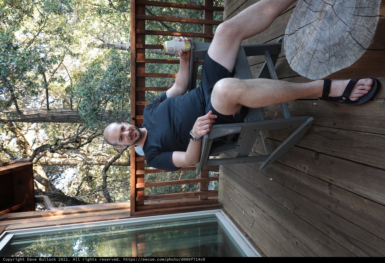 Man Relaxing on Wooden Deck Among Trees