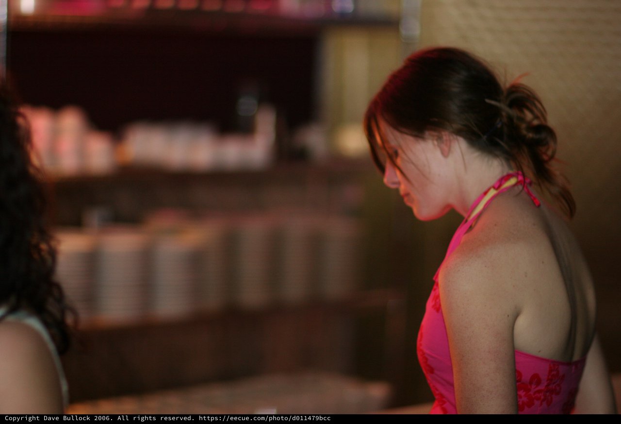Woman in Pink Halter Dress at Evening Bar