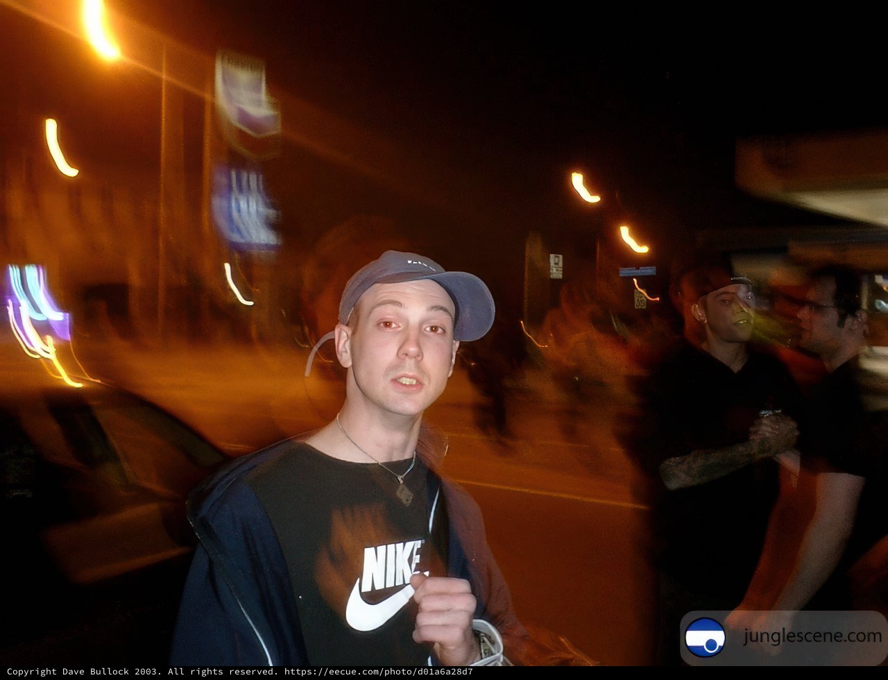 Blurry Nighttime Portrait of Man in Baseball Hat and Jacket