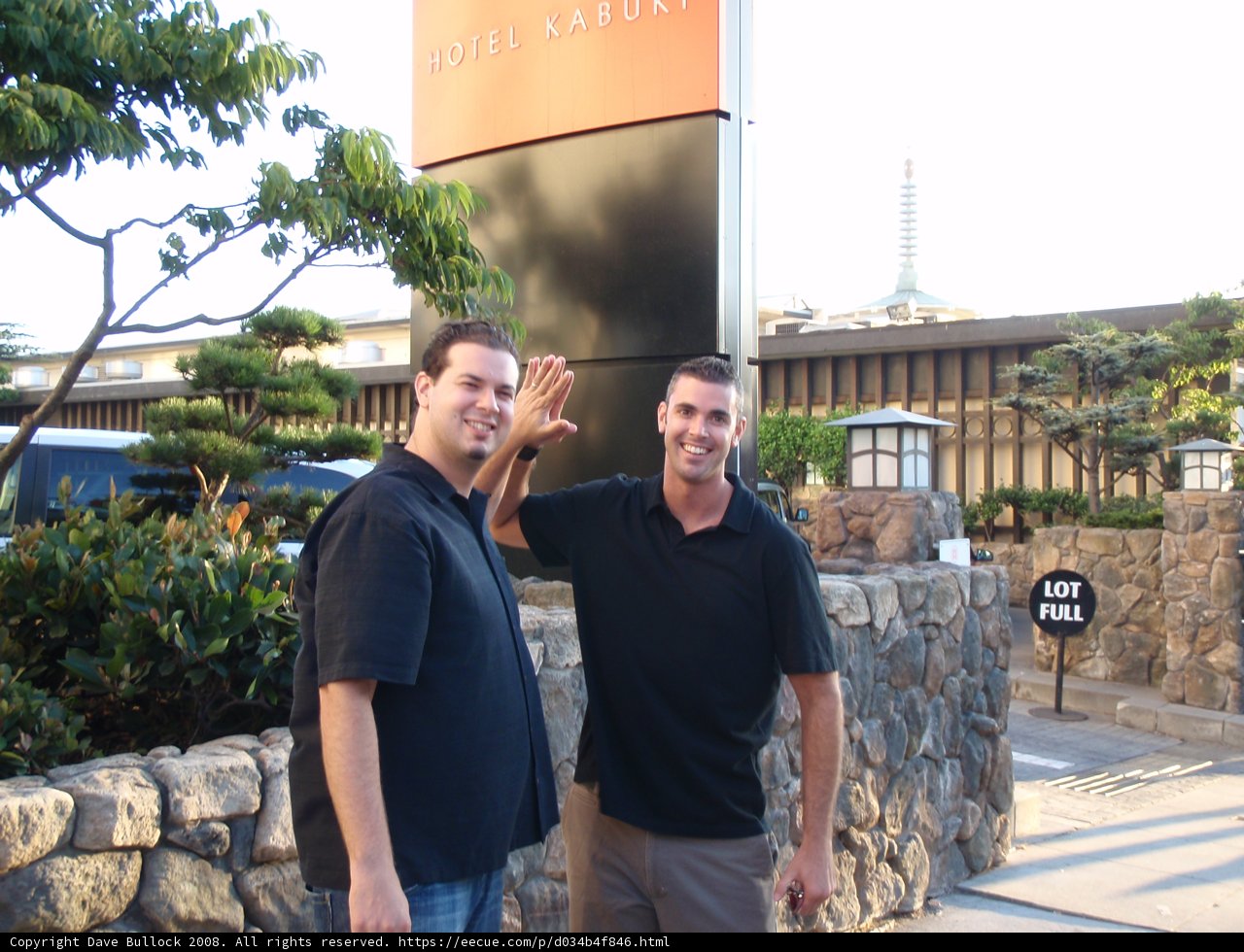 Two Men Standing in front of a Slate Wall