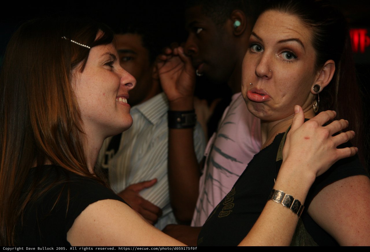 Two Women Share a Playful Moment at Nightclub